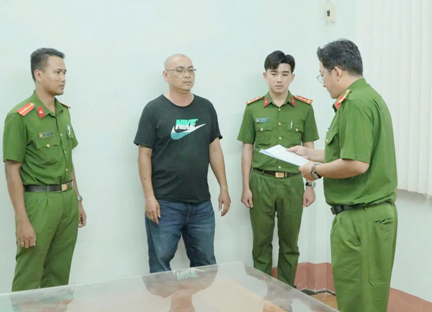 Chủ trại hòm Nhật Tâm nghe cơ quan điều tra đọc lệnh bắt tạm giam - Ảnh: CACC