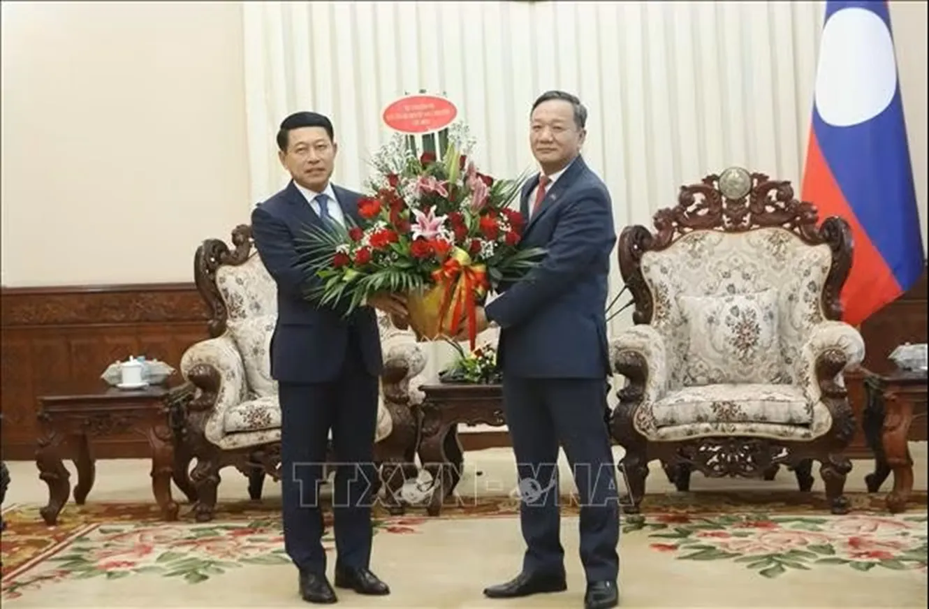 Đại sứ Việt Nam tại Lào Nguyễn Minh Tâm chuyển lẵng hoa chúc mừng của đồng chí Lê Minh Hưng, Ủy viên Bộ Chính trị, Thủ tướng Chính phủ Việt Nam chúc mừng đồng chí Saleumxay Kommasith, Ủy viên Bộ Chính trị, Thủ tướng Chính phủ Lào - Ảnh: Xuân Tú -PV TTXVN tại Lào