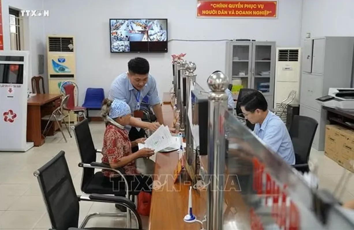 Cán bộ Trung tâm phục vụ hành chính công xã Yên Mỹ hướng dẫn hỗ trợ người già thực hiện thủ tục hành chính