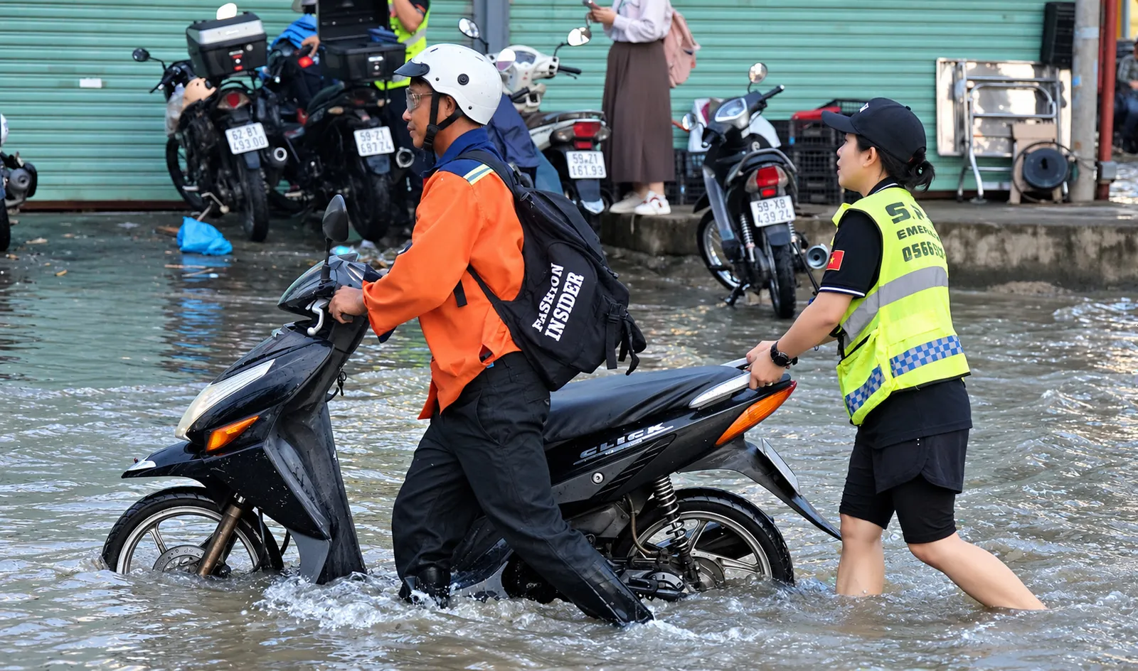 Giữa dòng triều cường, những bàn tay giúp người dân vượt ngập