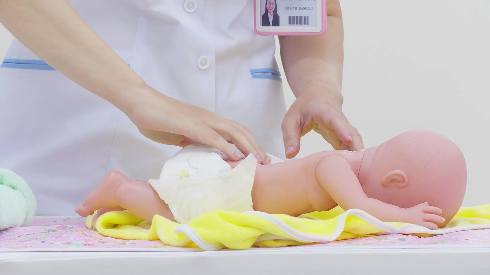 Nhân viên y tế hướng dẫn thao tác massage trên mô hình trẻ sơ sinh