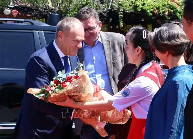 Tặng hoa chúc mừng Thủ tướng Ba Lan Donald Tusk thăm phố cổ Hội An. Ảnh: Trần Lê Lâm/TTXVN