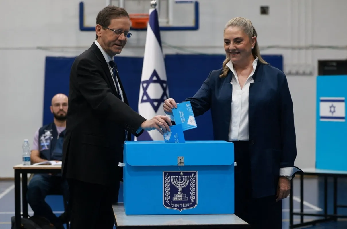 Tổng thống Israel Isaac Herzog và phu nhân đi bỏ phiếu tại một điểm bầu cử ở Jerusalem sáng 27-10 - Ảnh Reuters