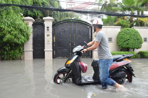 TPHCM mưa lớn, có nơi ngập nửa bánh xe